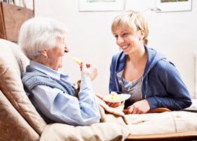 older_person_dietitian_smiling_eating_home.jpg