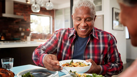 Older man eating fruit and vegetables at a table.jpg