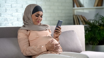 pregnant_woman_looking_at_phone.jpg