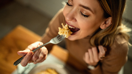 Woman happy while eating pasta food