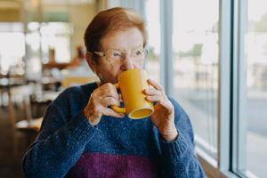 Older Woman Sipping Hot Drink Tea Coffee