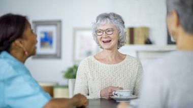 Senior older woman talking with friends 